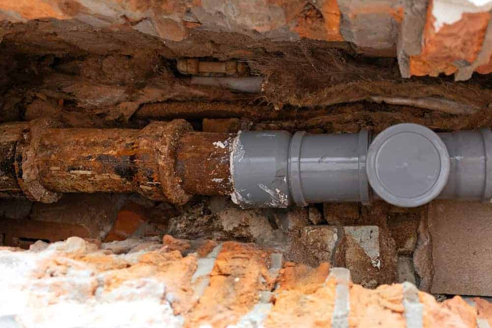 New PVC pipe section connected to old cast iron sewer line during a partial replacement repair in Chicago, Illinois